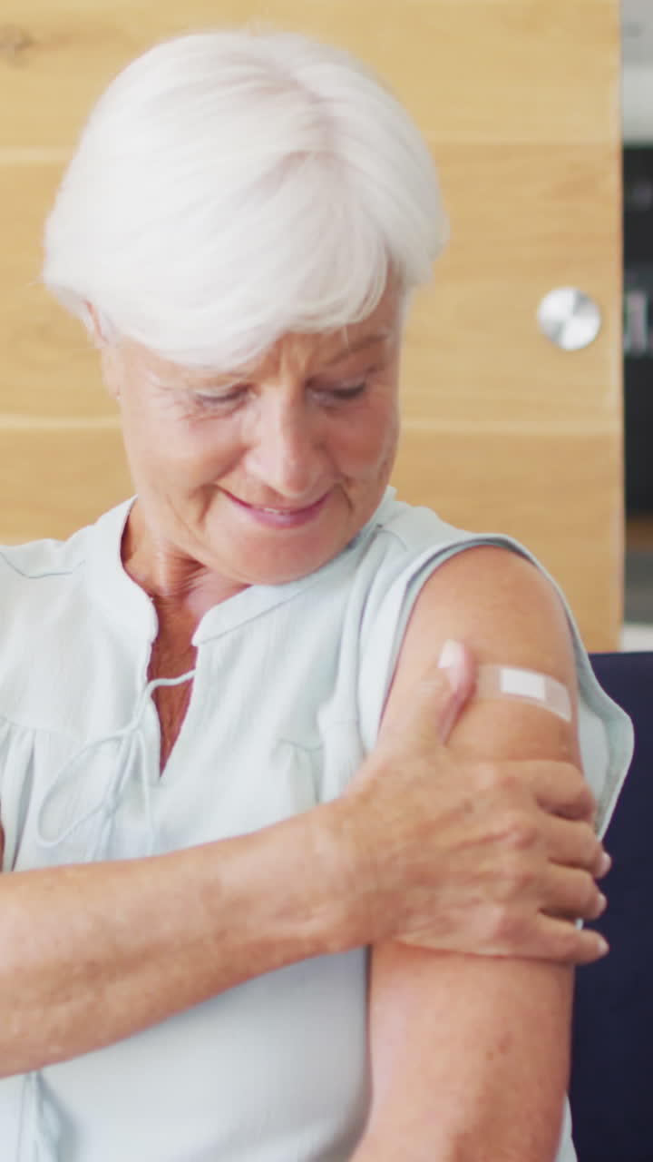 video de una feliz anciana caucásica que muestra el yeso después de la vacunación