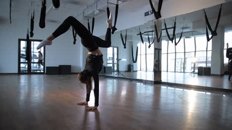 a spectacular dance performance in a studio featuring aerial yoga elements and talent an incredibly impressive dancer skillfully showcases remarkable flexibility and agility in an aerial yoga studio