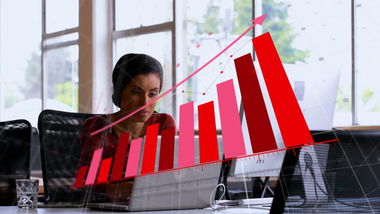Businesswoman working on laptop with red bar graph animation over office scene