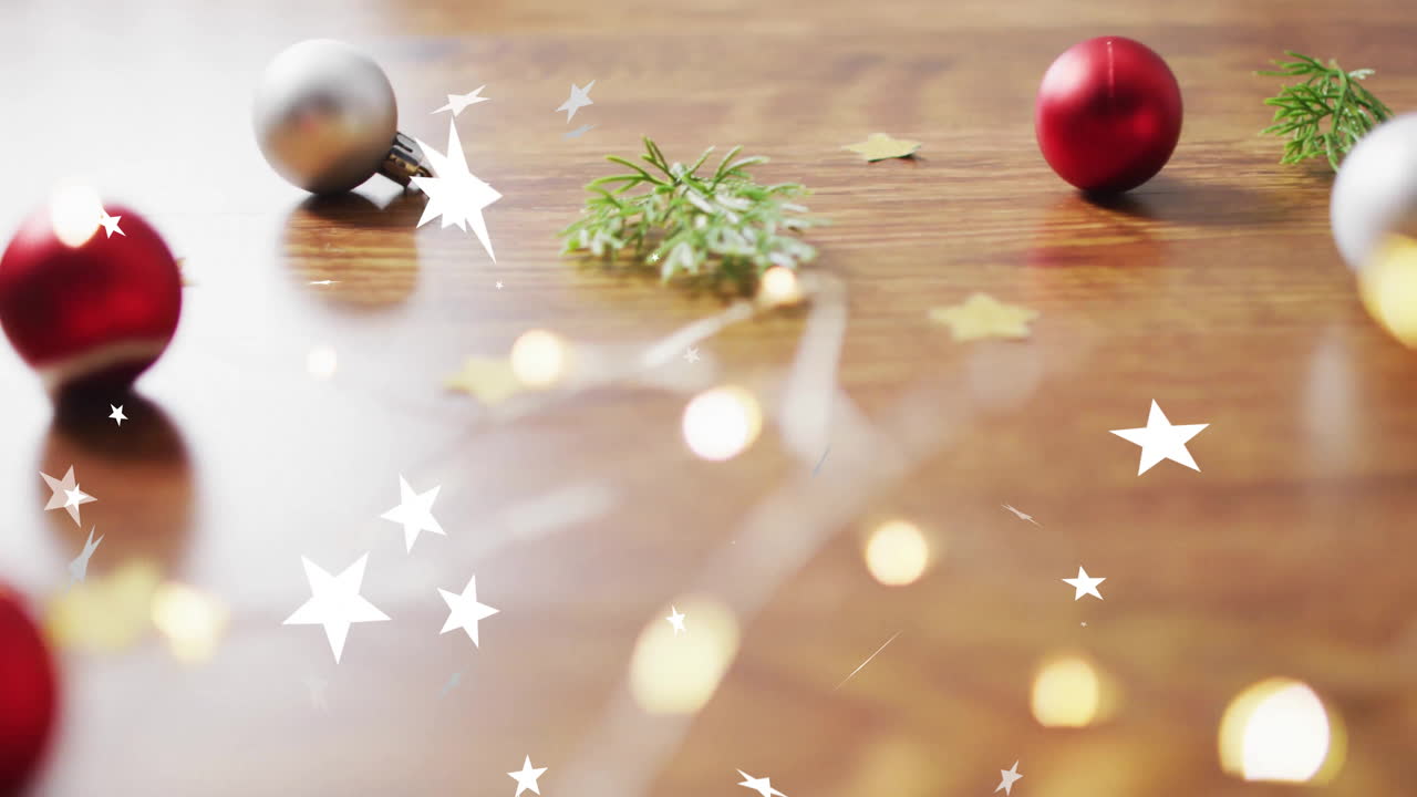 Baubles and greenery decorating wooden surface with star animation for Christmas