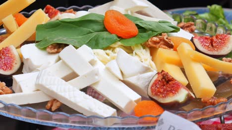 cheese board with figs, walnuts, and dried apricots