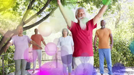 animation of spots of light and trees over diverse senior people practicing yoga in garden