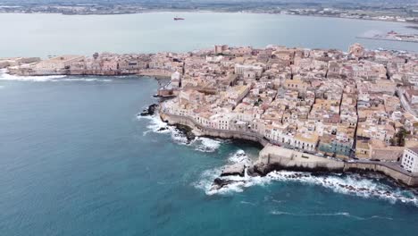 drone view over the whole ortigia of siracusa in sicily in italy, wavy sea