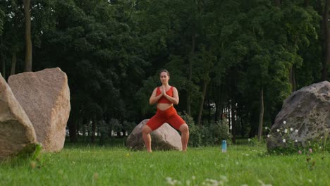 mujer embarazada practicando yoga en un parque