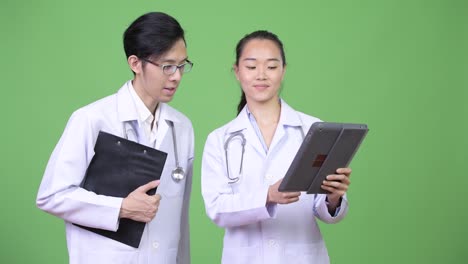 Young Asian couple doctors having meeting together