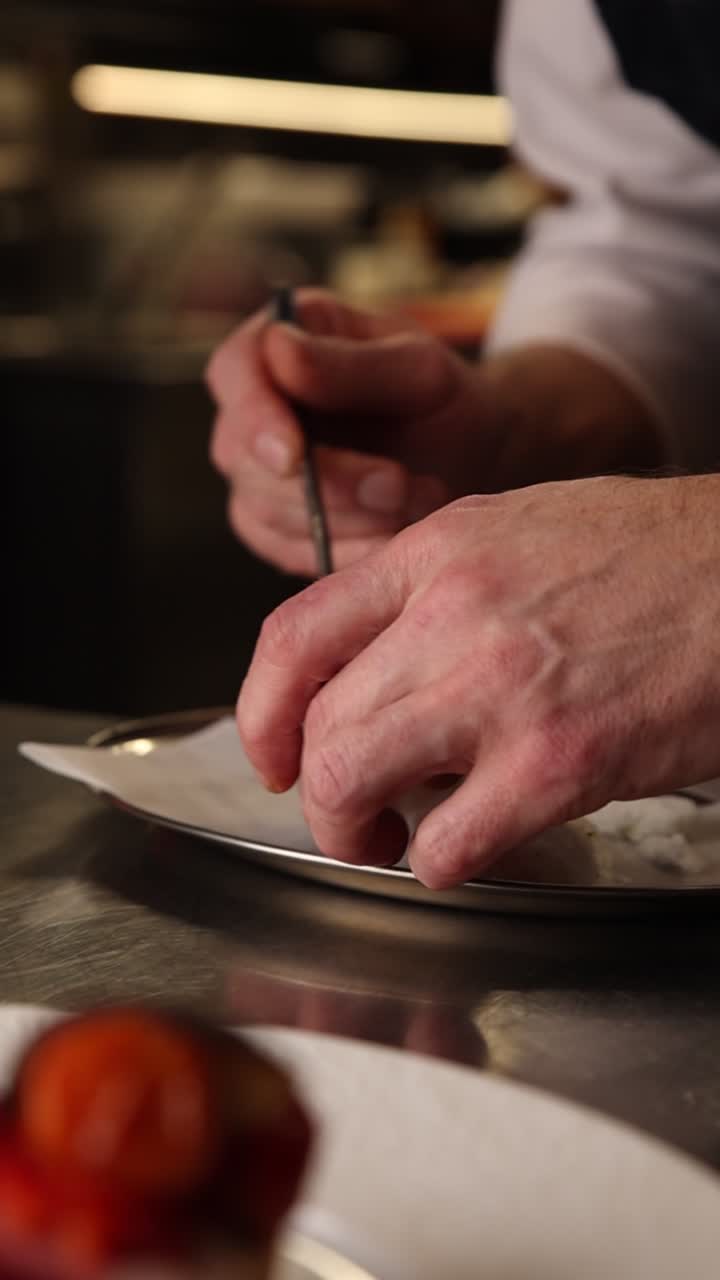 Chef's Hands Delicately Plating a Gourmet Dessert in a Professional Kitchen