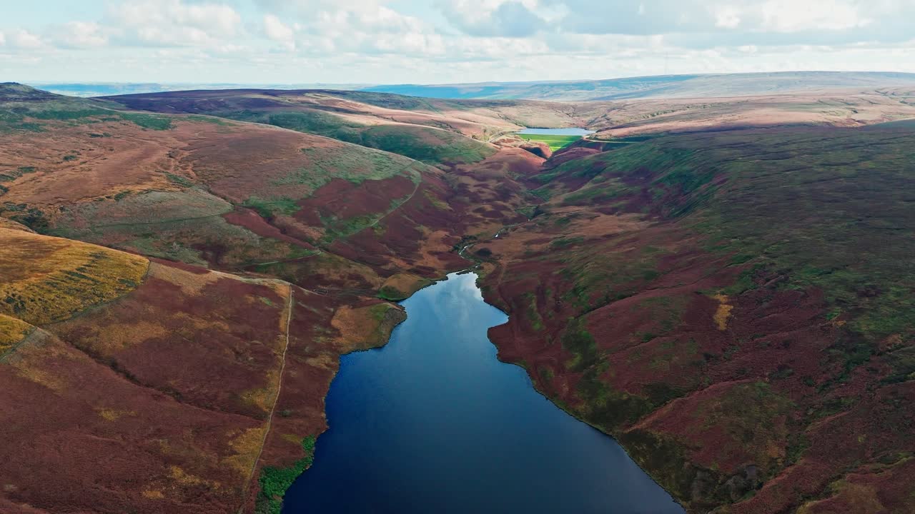 video aéreo de drones de la hermosa campiña inglesa, un paisaje salvaje que muestra páramos cubiertos de brezo, grandes lagos y agua azul