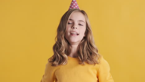 Teenage-Caucasian-girl-wearing-a-party-hat-and-dancing.