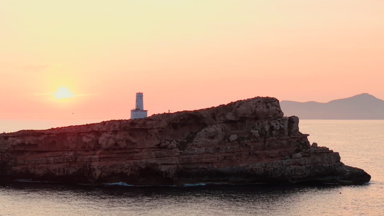 Fyr på en klippeø ved solnedgang