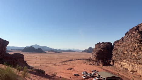 a wide establishing shot of the vast red desert sands of wadi rum with a bedouin camp in jordan 4k stable shot