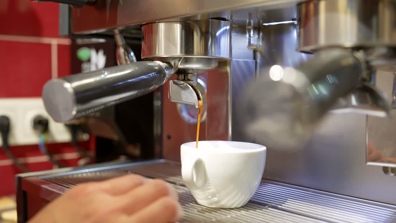 Primo piano di mani che preparano un caffè espresso in una macchina da caffè