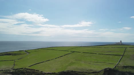 Dramatic-aerial-panorama-over-Galley-Head-peninsula-in-West-Cork-Ireland-with-a-lighthouse-on-a-sunny-day-and-open-view-over-ocean