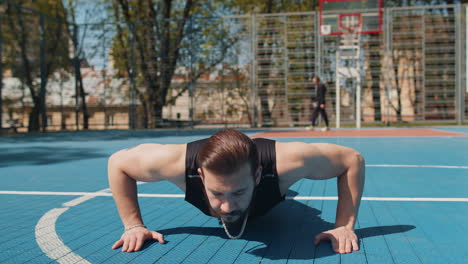athletic lebanese bodybuilder man in sportswear doing sport workout pushup exercise from ground