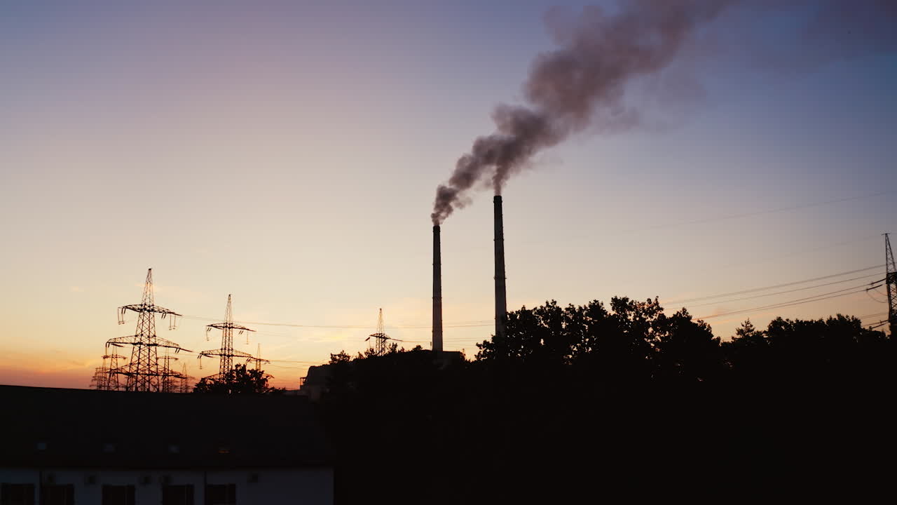 Smoke coming from pipes from factory at darkness. Chemical smoke going into the air from industrial pipes in the city.