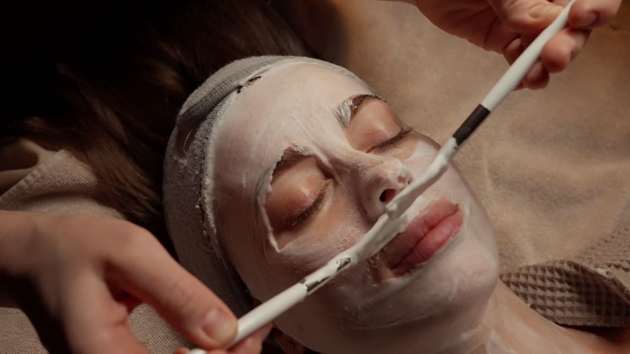 Estetista che applica una maschera viso sul volto di una donna