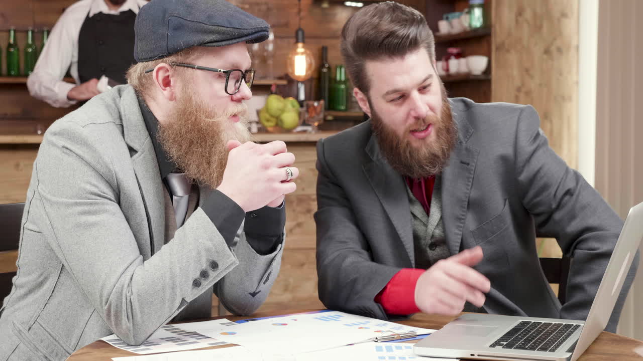 Businessmen collaborating on a project in a bar