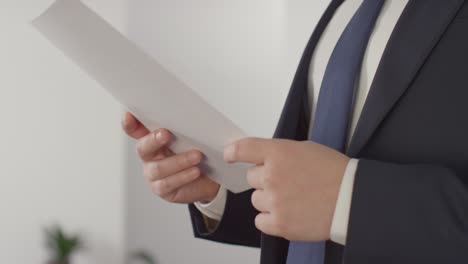 primer plano de un candidato masculino con traje en la oficina revisando notas antes de la entrevista de trabajo 1