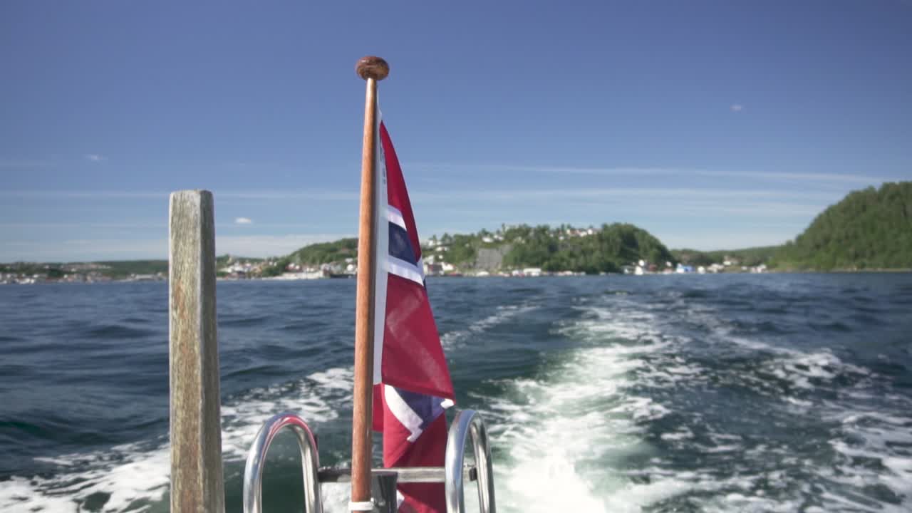 Norwegian flag on speedboat in the wind, Norway fjords boat trip, slow motion