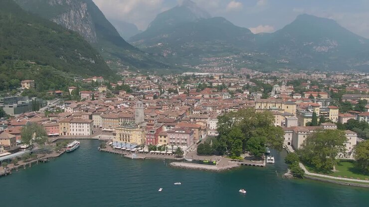 Vista aerea con drone della bellissima città di Riva del Garda e del Lago di Garda, circondati dalle Alpi italiane in estate.