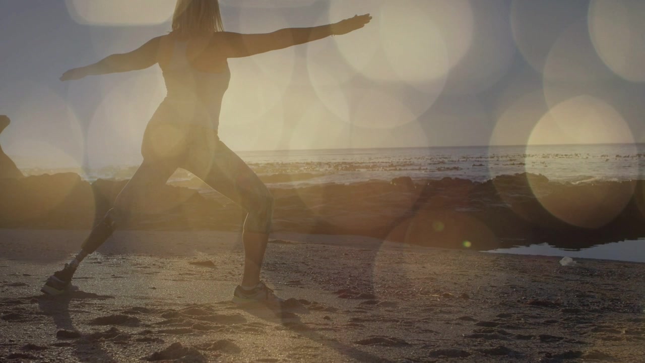 Donna anziana che esegue un affondo ampio, con le braccia estese che mantengono una posa yoga per la salute, con effetto bokeh sul corpo.