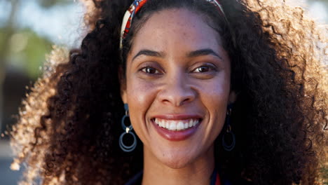 portrait of a smiling woman with curly hair and headband