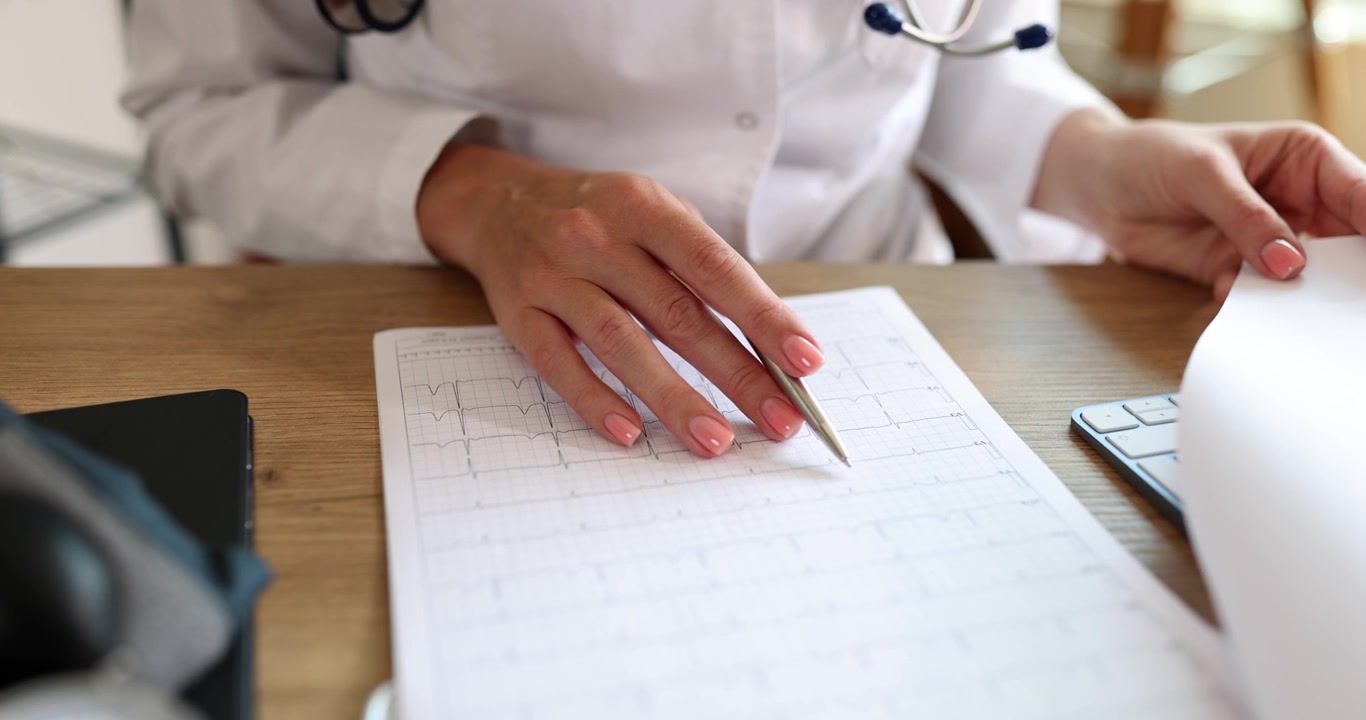 El cardiólogo observa los resultados del electrocardiograma.