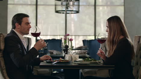 man and woman tasting red wine at restaurant dinner. couple dining in restaurant