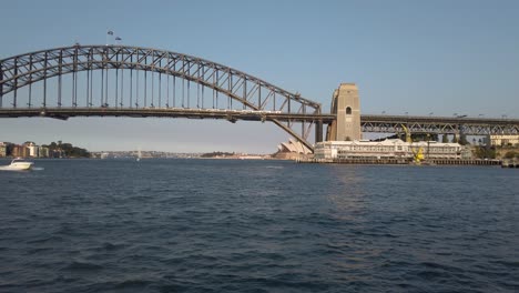 Ship-Sails-Away-From-Harbour-Bridge-At-Sunset-In-Sydney,-Australia