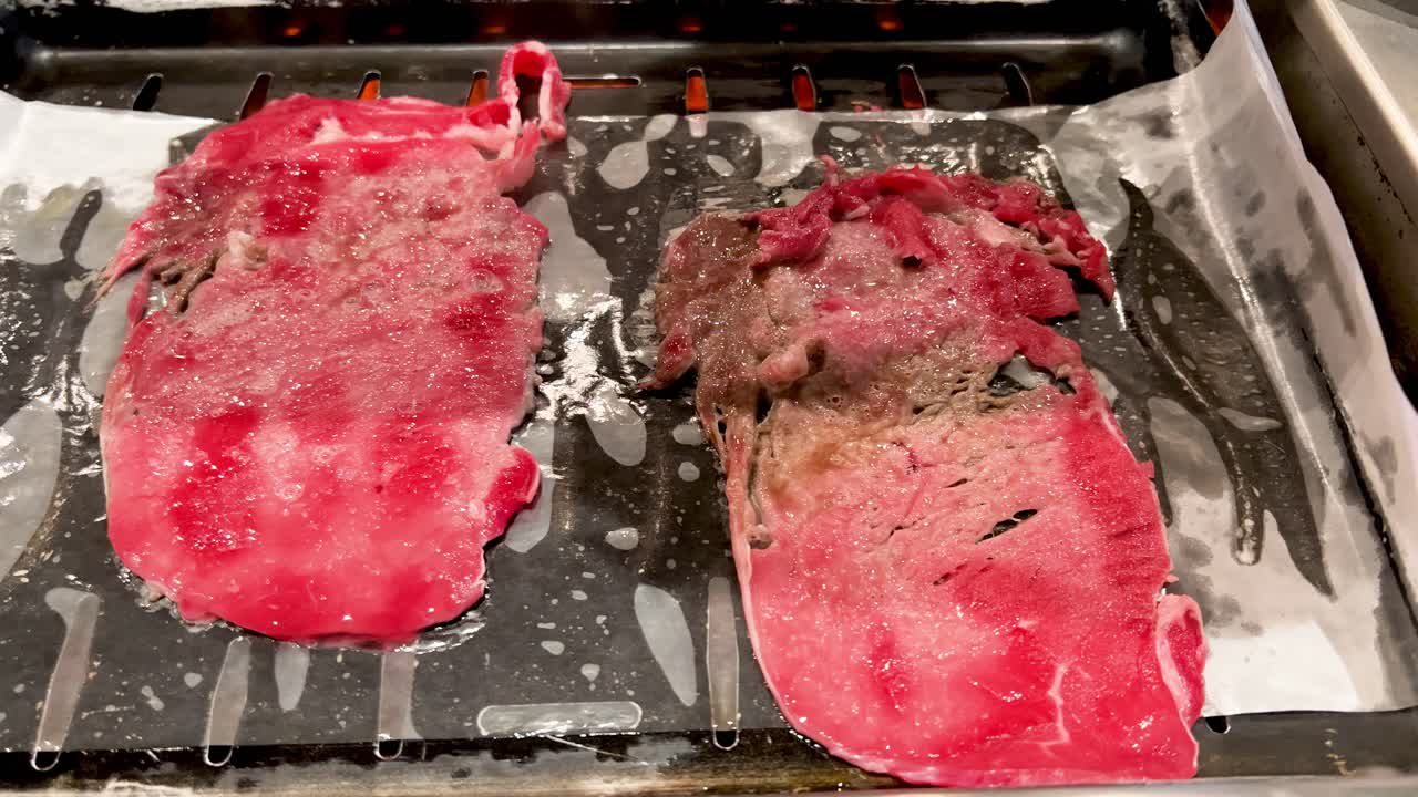 두 개의  ⁇ 은  ⁇ 고기 필레가 그릴에서  ⁇ 고 있는 클로즈업