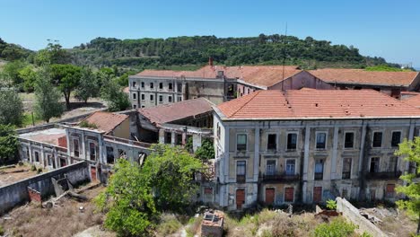 Drohnenaufnahme-Eines-Verlassenen-Gebäudes-Auf-Einem-Hügel-Am-Fluss-Tejo-In-Portugal