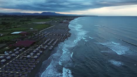 Vista-Aérea:-Vuelo-Costero-Temprano-En-La-Mañana:-Olas,-Montañas-Y-Serenidad-Frente-A-La-Playa.