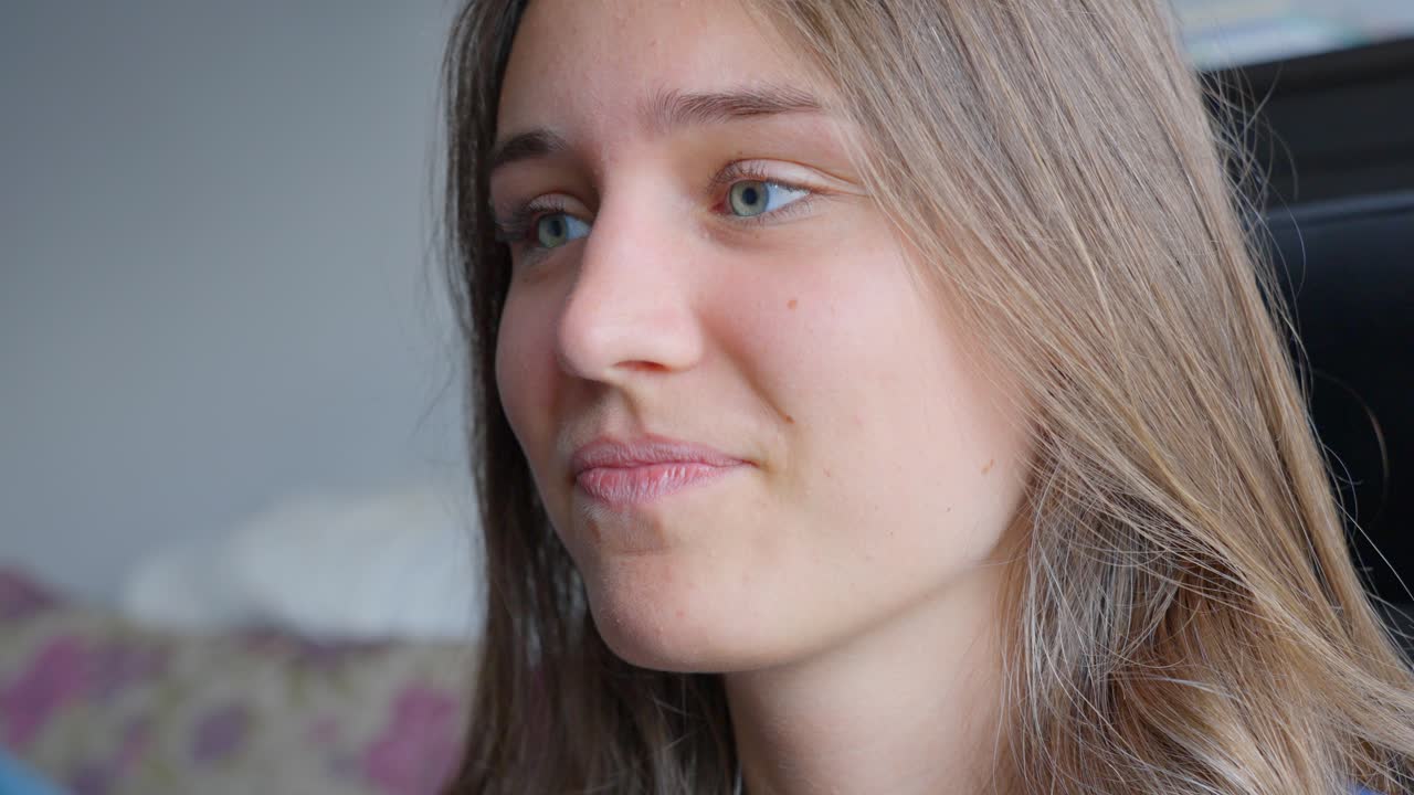 Close-up of woman smiling and listening while looking into camera
