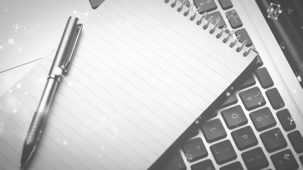 Animation of molecules moving over laptop, notebook and pen on desk