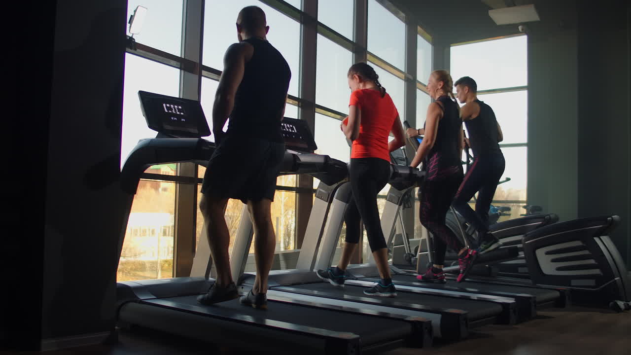 Healthy People running on machine treadmill at fitness gym Work. Out concept. People doing cardio training on treadmill in gym
