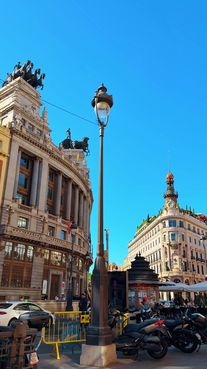 Madrid, Španělsko, 8. srpna 2025: Edificio Metropoli a Banco de España v Madridu. Pohled z ulice s kvadrigou na budově Banco de España a klasickou madridskou architekturou