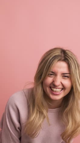 blonde caucasian young woman laughing energetically standing