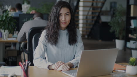 mujer trabajando en una computadora portátil en una oficina moderna