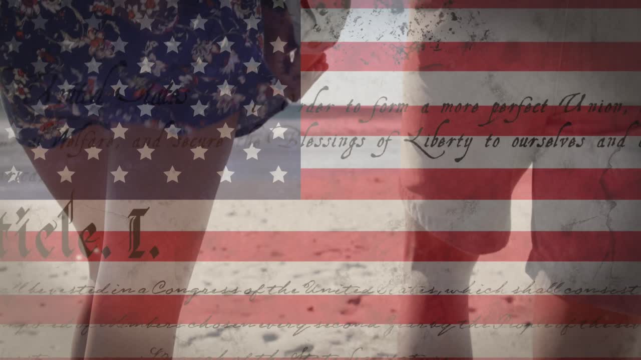 animación de la bandera estadounidense ondeando y el texto de la constitución sobre una pareja de raza mixta a orillas del mar