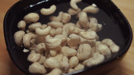 peanuts soaking in water in black bowl