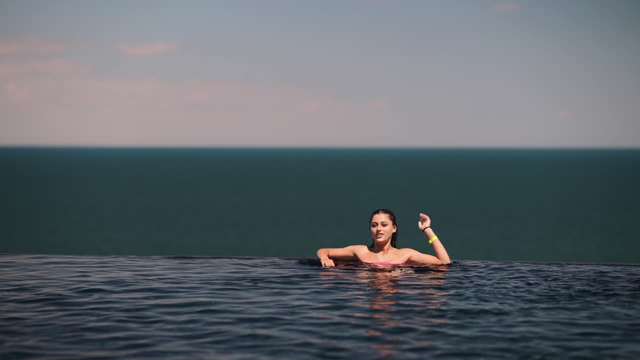 바다를 바라보는 수영장에서 휴식을 취하는 여자