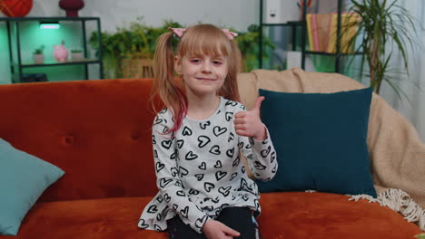 Happy-young-little-girl-kid-raises-thumbs-up,-good-feedback,-like-approve-positive-sign-gesture