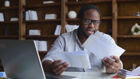 smiling african-american guy holding envelopes