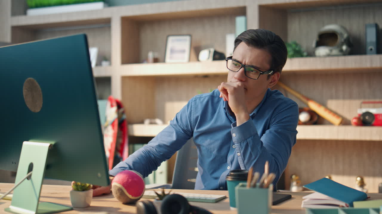 freelancer pensativo enviando mensajes de texto computadora trabajando en la oficina de cerca. hombre charlando