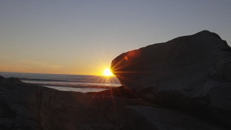 astonishing sunset behing rock at kvalvika beach, lofoten, norway