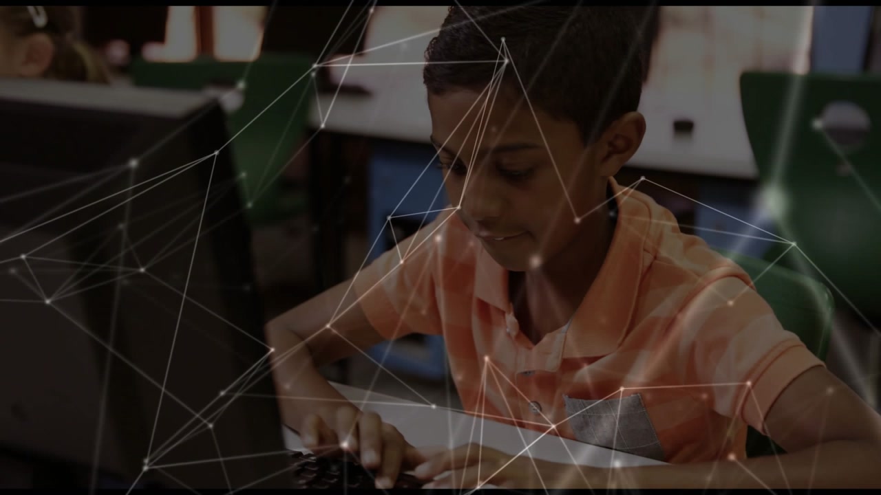 Schoolboy placing hands on keyboard, following prompts while typing with technology overlay