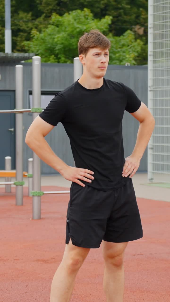 Male athlete stands ready outdoors, focused and determined on a sunny day, vertical