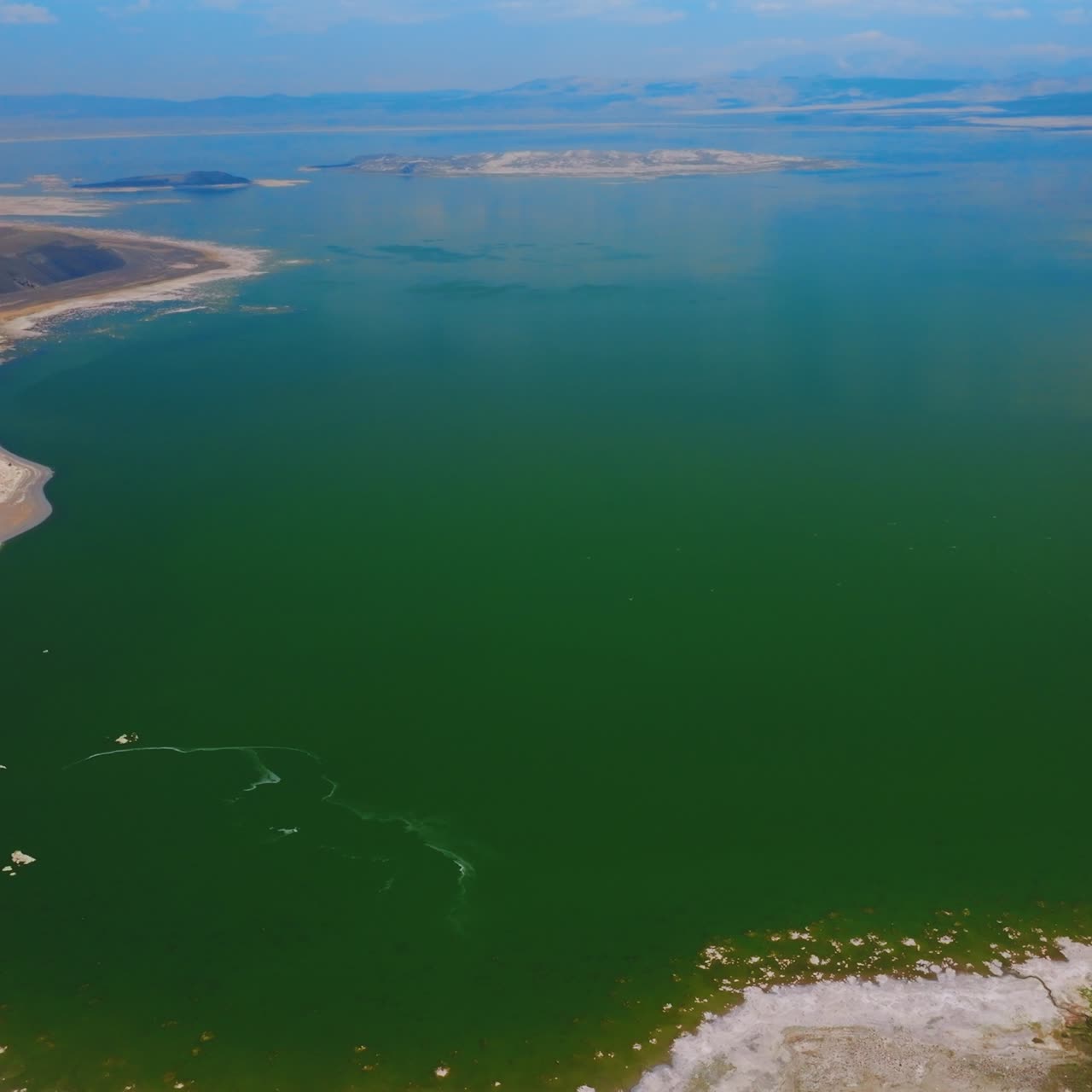 Mono Lake panorama surrounded by salty shores. Azure of the lake merging with blue sky at horizon. Top view