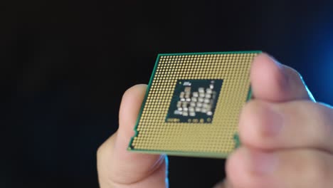 vista de primer plano del procesador de cpu sostenido por un técnico, fondo negro de enfoque de rack
