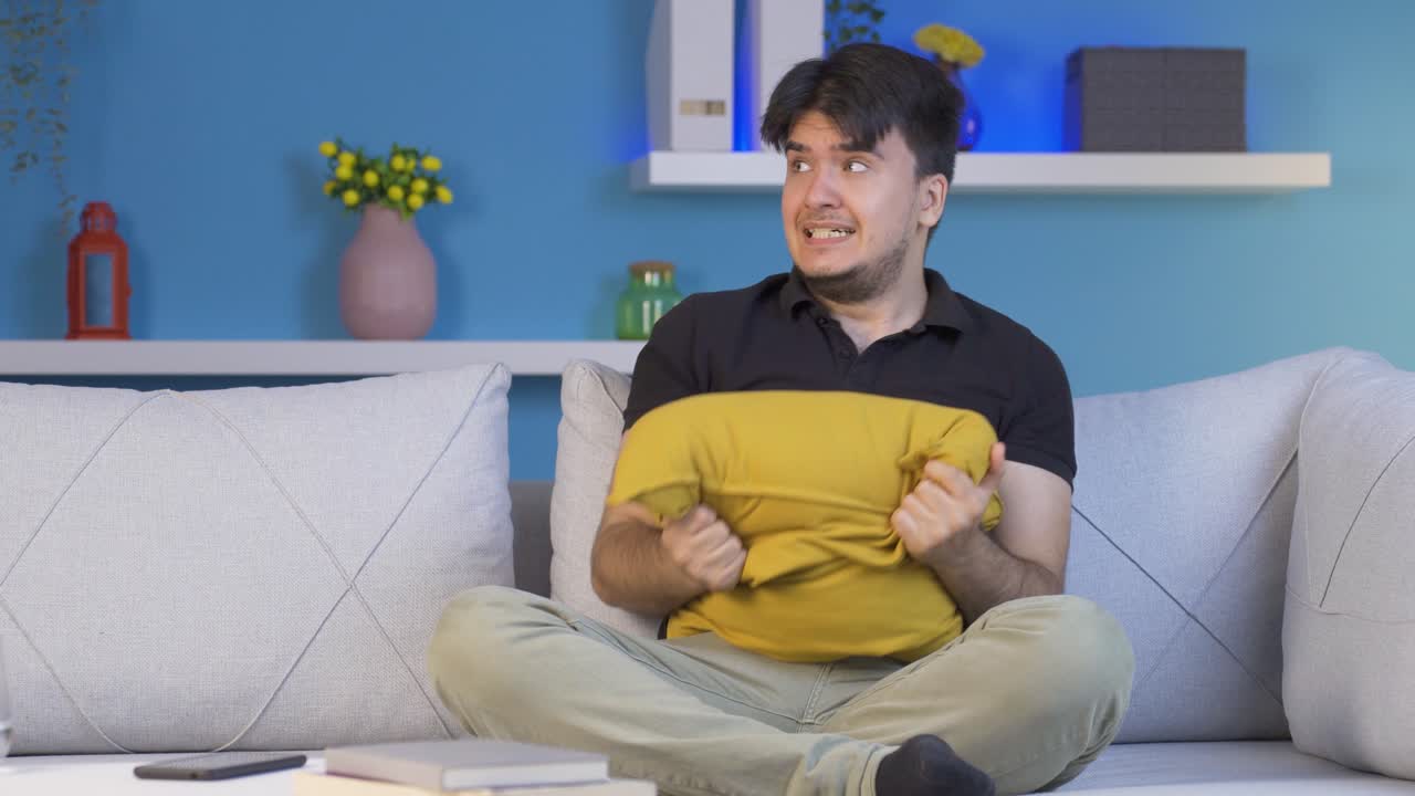 두려움으로 머리에 베개를 누르는 사람.