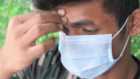 young man wearing a mask with headache